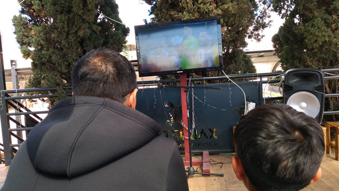 Aficionados en Xaloztoc ven el partido de México vs Argentina en el parque