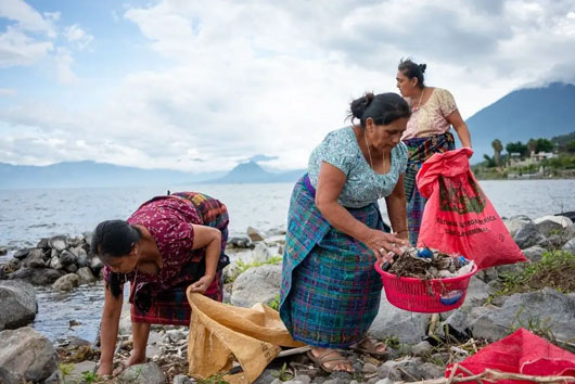 “Guardianas” indígenas limpian lago amenazado por contaminación en Guatemala